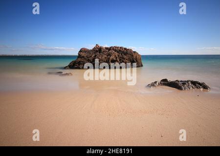 Bella vista formazione rocciosa sulla spiaggia contro un cielo blu in una giornata di sole Foto Stock