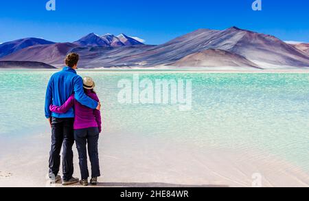 Coppia godere di vista sulla Laguna Salar de talar con il Monte Andes, San Pedro de Atacama, Cile Foto Stock