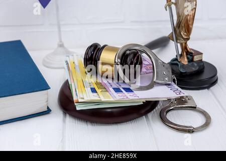 Manette con banconote in euro e gavel del giudice Foto Stock