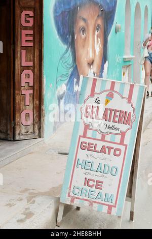 Cartello all'esterno di una gelateria accanto a un murale su Isla Holbox, Messico Foto Stock