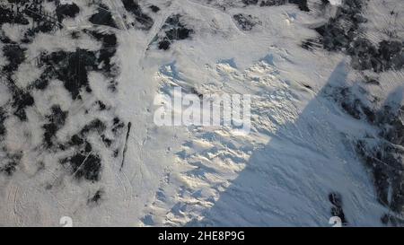 Vista dall'alto dello sfondo della struttura del ghiaccio. Vista aerea del paesaggio naturale invernale delle acque ghiacciate del lago o stagno con neve bianca. Foto Stock