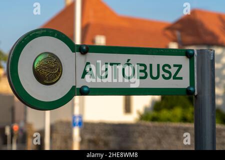 Vista ravvicinata di un cartello verde della fermata dell'autobus ungherese nella città universitaria di Pecs che dice 'bus' Foto Stock