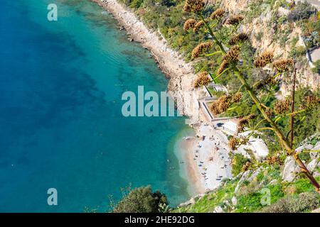 Guardando in basso sulla spiaggia di Arvanitia dalla Fortezza Veneziana Palamidi insieme al mare e alla penisola della città di Nauplia, nella regione del Peloponneso Foto Stock