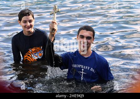 Orlando, Stati Uniti. 09th Jan 2022. Isaac Abdelmessih tiene la croce dopo averla recuperata dal lago Eola durante la celebrazione annuale dell'immersione incrociata dell'Epifania che si tiene presso la chiesa ortodossa di St. George nel centro di Orlando. La celebrazione onora il battesimo di Gesù Cristo e si dice che chi recupera la croce riceverà buona fortuna per il resto dell'anno. Credit: SOPA Images Limited/Alamy Live News Foto Stock