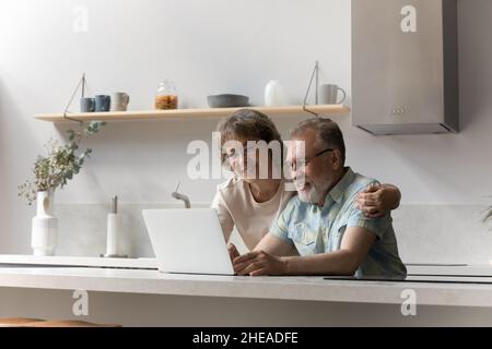 Buon legame coppia matura usando il laptop a casa. Foto Stock