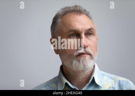 Primo piano testa colpo uomo anziano pensivo guardando in lontananza. Foto Stock