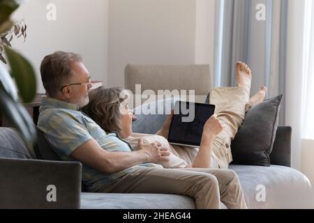 Felice coppia di mezza età che usa il portatile a casa. Foto Stock
