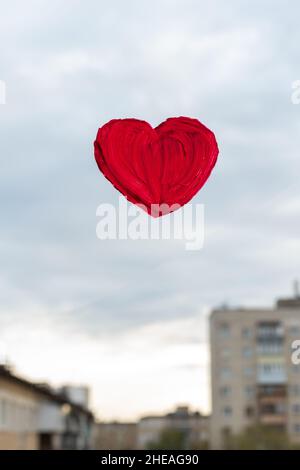 Cuore rosso dipinto con pitture sul vetro della finestra che si affaccia sulla strada. Concetto di San Valentino. Concetto di amore e di rapporto Foto Stock