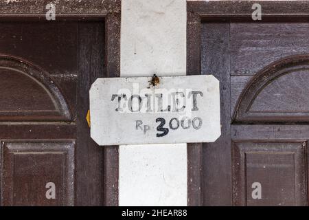 Carta IGIENICA in cartoncino manoscritta sulla parete di un gabinetto pubblico a Bali, Indonesia con prezzo Rp. 3000 (in rupia indonesiana) Foto Stock