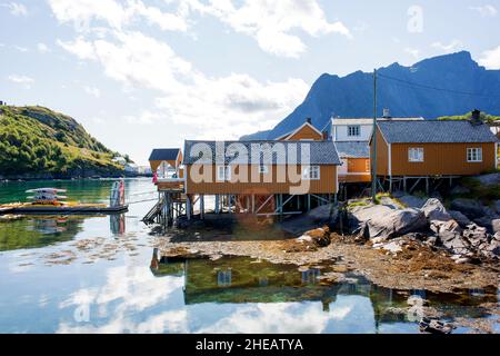 Splendida vista su una splendida natura norvegese e tipiche piccole cabine di pesca in una soleggiata giornata estiva sui fiordi, Lofoten, Norvegia Foto Stock