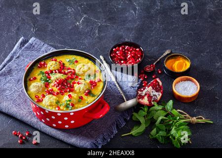 Ash-e Anar, zuppa di Pomegranate di piselli persiana con polpette di agnello in una pentola rossa su un tavolo di cemento con ingredienti vista orizzontale dall'alto, gratis Foto Stock