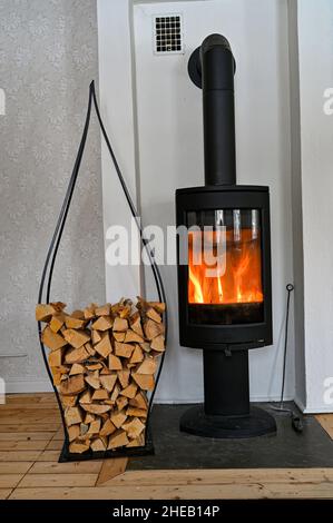 Mucchio di legna da ardere e stufa a combustione calda Foto Stock