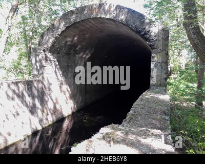 Un flusso d'acqua esce da un vecchio bunker sotterraneo incompiuto Foto Stock