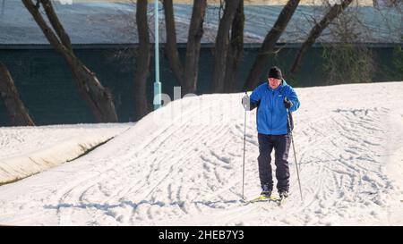 L'uomo anziano sta sciando su una pista da sci in inverno fuori. Sci di fondo Foto Stock