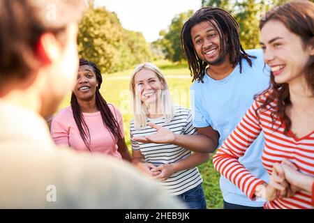 Gruppo diversificato di giovani come amici e studenti che hanno piccoli discorsi nel parco in estate Foto Stock