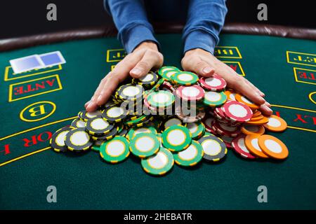 Giocatore di poker andare all-in spingendo le sue chip in avanti Foto Stock