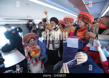 (220110) -- CHENGDU, 10 gennaio 2022 (Xinhua) -- la gente del gruppo etnico di Lisu dalla contea di Dechang esibisce sul treno ad alta velocità D843 'Fuxing', nella prefettura autonoma di Liangshan Yi, nella provincia sudoccidentale del Sichuan della Cina, 10 gennaio 2022. Un'unità multipla elettrica ad alta velocità (EMU) 'Fuxing' ha lasciato la città di Xichang nella prefettura autonoma di Liangshan Yi, provincia del Sichuan della Cina sud-occidentale, per Kunming, capitale della provincia dello Yunnan della Cina sud-occidentale, lunedì. Ha segnato la partenza del primo treno ad alta velocità 'Fuxing' dalla prefettura nella remota montagna di Daliang, una delle aree più recenti della Cina per agitare via ab Foto Stock