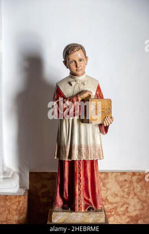 Modello di giovane ragazzo che tiene la scatola di raccolta offertorio all'uscita della chiesa, Frigiliana, provincia di Malaga, Spagna Foto Stock