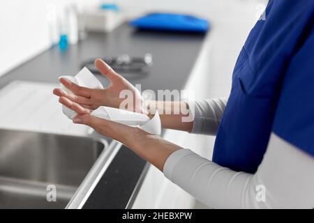 medico o infermiere che asciuga le mani con un fazzoletto di carta Foto Stock