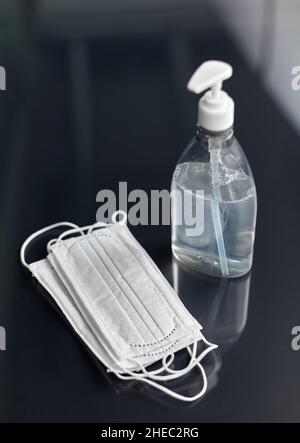 disinfettante per le mani o sapone liquido e maschere mediche Foto Stock