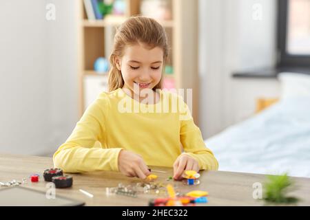 ragazza felice che gioca con il kit robotica a casa Foto Stock