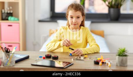 ragazza felice che gioca con il kit robotica a casa Foto Stock