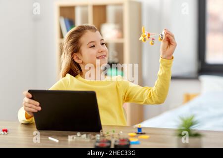 ragazza con tablet pc e kit robotico a casa Foto Stock