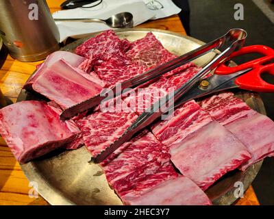 Rack di carne fresca pronti per essere grigliati in un ristorante coreano per Kalbi Foto Stock