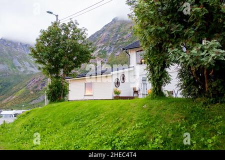 Veduta aerea di Husoy, piccolo villaggio su una piccola isola appartenente alla grande isola di Senja ed essendo circondato da un bel paesaggio di montagna Foto Stock