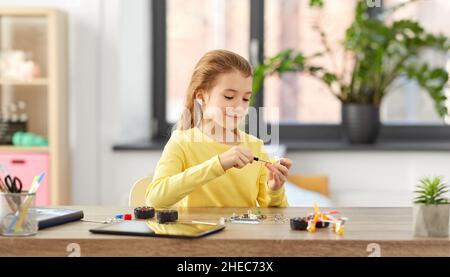 ragazza felice che gioca con il kit robotica a casa Foto Stock