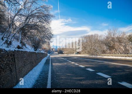 Strada e paesaggio innevato. Somosierra, provincia di Madrid, Spagna. Foto Stock