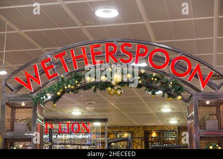 Cartello / segnaletica al Red Lion Wetherspoon / Wetherspoons Pub / ristorante / Public House, presso l'aeroporto di Gatwick di Londra North Terminal, Crawley. REGNO UNITO. Decorazioni natalizie sono visibili. (128) Foto Stock