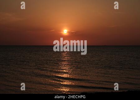 Romantico tramonto con luce dorata sul Mar baltico in una spiaggia di ciottoli dell'isola di Fehmarn, Germania Foto Stock