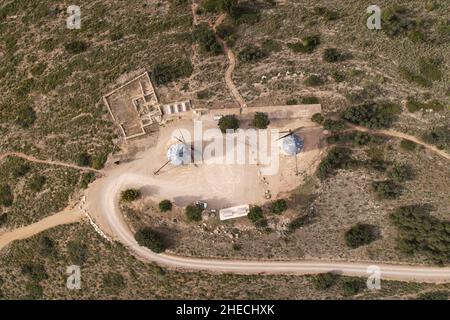 Panoramica veduta aerea dall'alto di due antichi mulini a vento recuperati sulla cima di una collina in Alcublas, Spagna Foto Stock