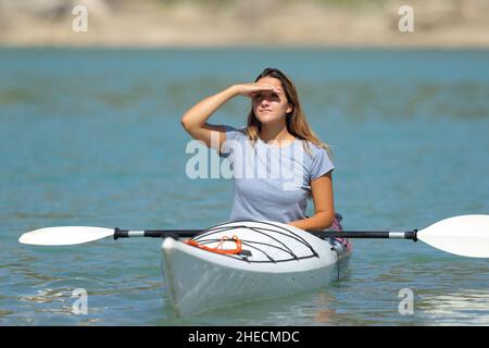 Donna in un kayak alla ricerca di proteggere dal sole con mano in vacanza estiva Foto Stock