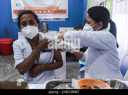 Guwahati, India. 10th Jan 2022. Un infermiere somministra una dose di richiamo del vaccino COVID-19 ad un operatore sanitario n a Guwahati, Assam, India lunedì 10 gennaio 2022. La vaccinazione per la terza dose o la ''˜dose precauzionale per i gruppi prioritari '''' operatori sanitari, operatori di prima linea e di età superiore ai 60 anni con comorbidità è iniziata lunedì. (Credit Image: © David Talukdar/ZUMA Press Wire) Foto Stock