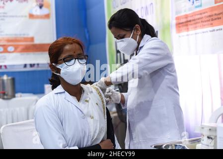 Guwahati, India. 10th Jan 2022. Un infermiere somministra una dose di richiamo del vaccino COVID-19 ad un operatore sanitario n a Guwahati, Assam, India lunedì 10 gennaio 2022. La vaccinazione per la terza dose o la ''˜dose precauzionale per i gruppi prioritari '''' operatori sanitari, operatori di prima linea e di età superiore ai 60 anni con comorbidità è iniziata lunedì. (Credit Image: © David Talukdar/ZUMA Press Wire) Foto Stock