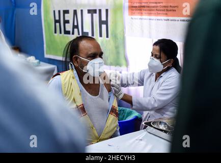 Guwahati, India. 10th Jan 2022. Un infermiere somministra una dose di richiamo del vaccino COVID-19 ad un anziano di Guwahati, Assam, India lunedì 10 gennaio 2022. La campagna di vaccinazione per la terza dose o ''˜dose precauzionale per gruppi prioritari - operatori sanitari, operatori di prima linea e di età superiore a 60 anni con comorbidità è iniziata lunedì. (Credit Image: © David Talukdar/ZUMA Press Wire) Foto Stock