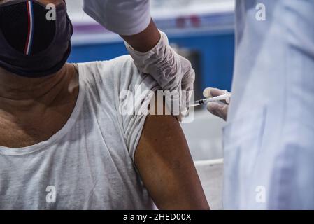 Guwahati, India. 10th Jan 2022. Un infermiere somministra una dose di richiamo del vaccino COVID-19 ad un anziano di Guwahati, Assam, India lunedì 10 gennaio 2022. La campagna di vaccinazione per la terza dose o ''˜dose precauzionale per gruppi prioritari - operatori sanitari, operatori di prima linea e di età superiore a 60 anni con comorbidità è iniziata lunedì. (Credit Image: © David Talukdar/ZUMA Press Wire) Foto Stock