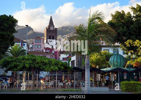 Portogallo, Isola di Madeira, Funchal, caffè terrazza sul lungomare e la Cattedrale di nostra Signora dell'Assunzione Foto Stock