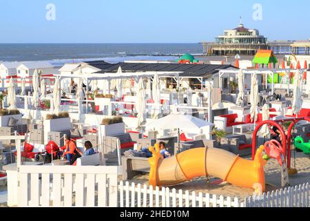 Belgio, Fiandre Occidentali, Blankenberghe, giochi da spiaggia con il molo di Blankenberge (molo del Belgio) sullo sfondo Foto Stock