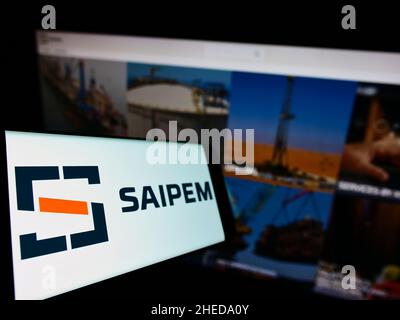 Smartphone con logo della società italiana Saipem S.p.A. di servizi petroliferi sullo schermo di fronte al sito web aziendale. Mettere a fuoco sulla sinistra del display del telefono. Foto Stock