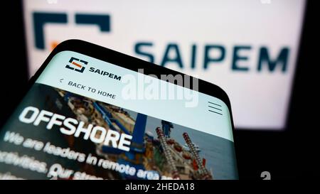 Telefono cellulare con sito web della società italiana Saipem S.p.A. di servizi petroliferi sullo schermo di fronte al logo. Mettere a fuoco sulla parte superiore sinistra del display del telefono. Foto Stock