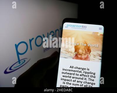 Persona che detiene il cellulare con il sito web della società farmaceutica statunitense Provention Bio Inc. Su schermo con il logo. Concentrarsi sul centro del display del telefono. Foto Stock