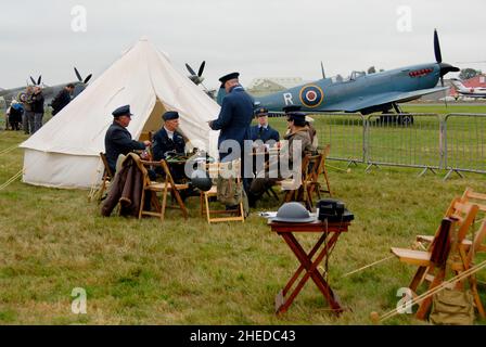 Rievocazione al Biggin Hill Airshow con persone che agiscono come ufficiali e NCO, equipaggio e personale di supporto, con foto di ricognizione Spitfire Beyond Foto Stock