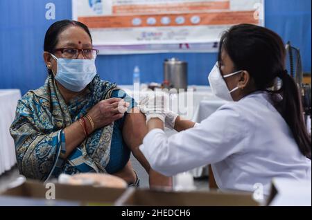 Guwahati, India. 10th Jan 2022. Un infermiere somministra una dose di richiamo del vaccino COVID-19 ad un anziano di Guwahati, Assam, India lunedì 10 gennaio 2022. La campagna di vaccinazione per la terza dose o ''˜dose precauzionale per gruppi prioritari - operatori sanitari, operatori di prima linea e di età superiore a 60 anni con comorbidità è iniziata lunedì. (Credit Image: © David Talukdar/ZUMA Press Wire) Foto Stock