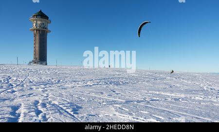 Feldberg, Germania - 19 dicembre 2021: 1 Sport invernali nella neve. Carenino con zaino sugli sci davanti al cielo blu. Feldberg torre su un Wi soleggiato Foto Stock