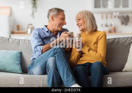 Allegro coppia matura bere caffè clinking Cups a casa Foto Stock