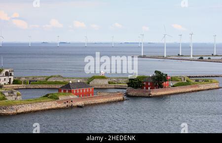 Trekroner o tre corone fortificazione in avvicinamento al porto di Copenaghen, Danimarca. Alcune delle molte turbine eoliche offshore in background. Foto Stock