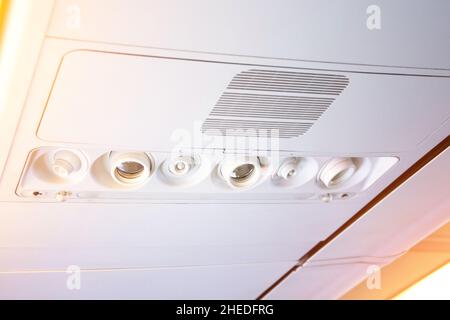 Console a padiglione nel moderno aeromobile passeggeri. Pulsante aria condizionata e interruttore di illuminazione, pulsanti di chiamata dell'assistente di volo Foto Stock